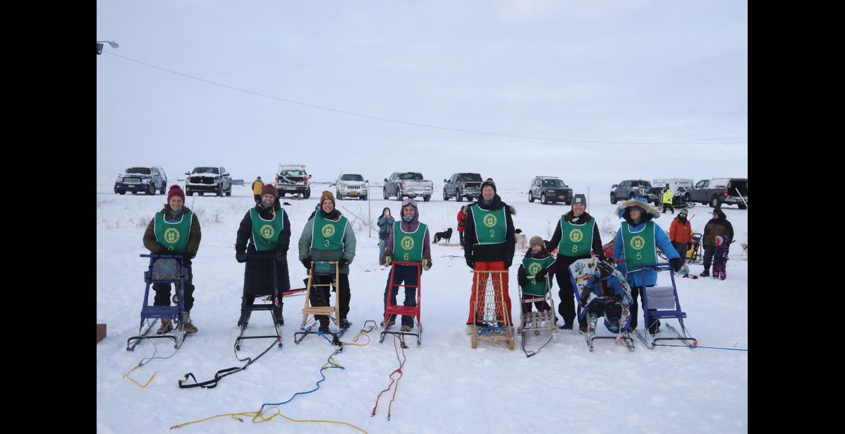 Photo by Laura Robertson HAVING FUN—Mushers pose before the start of the kick sledding fun run. From left, they are: Danielle Sem, Emilie Loran, Sam Pollee, Alicia Reitz, Garrick Fuller, Cassie Fuller, Valerie Fuller, Max Fuller and Tami Seward Thompson.