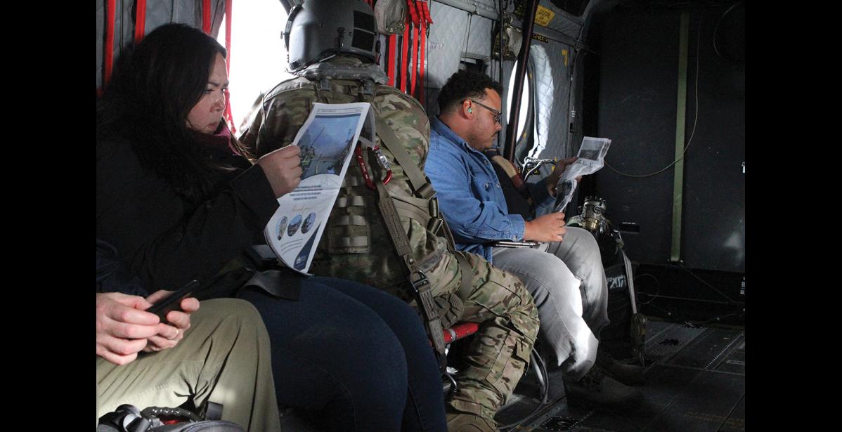 Photo by Peter Loewi FEMA and Congressional staffers read The Nome Nugget on a helicopter flight to Golovin.