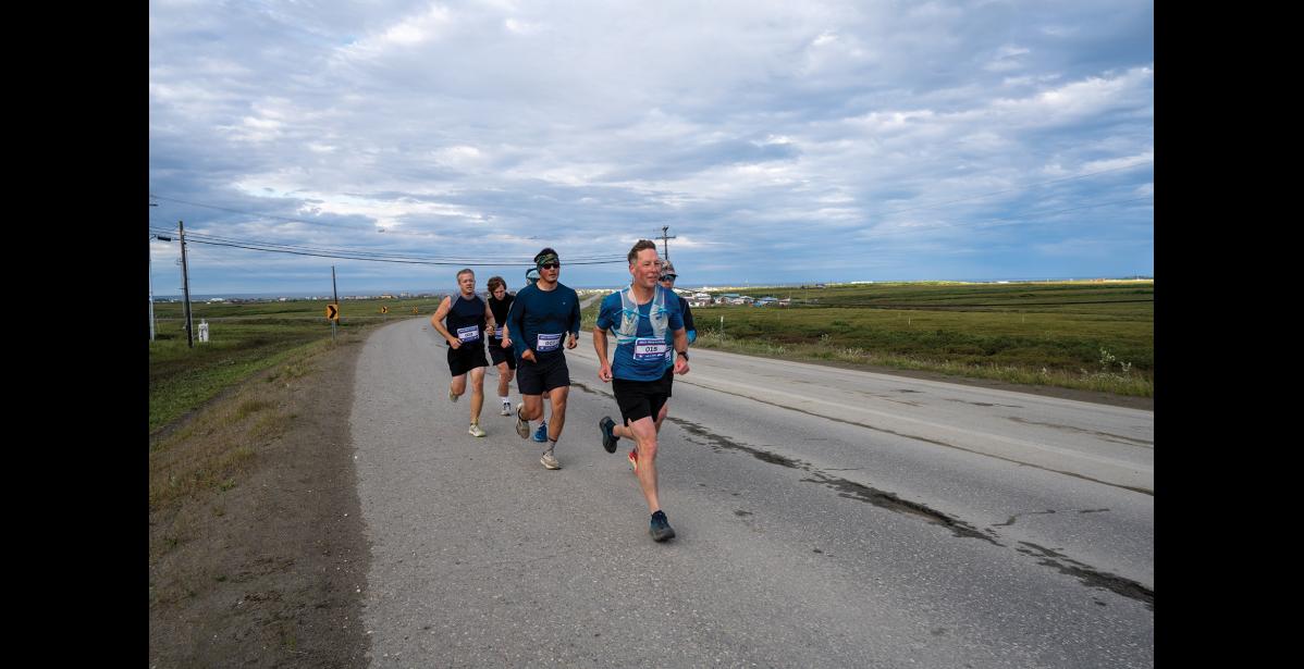DRAFTING— Tyler Rhodes leads the Anvil Mountain Run outbound at the Nome-Teller Highway. Behind him is Tobin Hobbs, Oliver Hoogendorn, Nicholai Olson and two unidentified runners. Photo by Ariana Crockett O’Harra