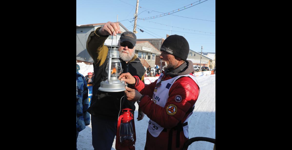 Photo by Diana Haecker Jason Mackey extinguishes the widow's lantern as the last musher off the trail on the 2023 Iditarod.