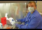 RAPID TESTING— Alex Bahnke, a general supervisor in the NSHC Laboratory, prepares to run a COVID-19 test on one of the new Abbott ID Now machines from under the safety of a fume hood in the Nome lab.