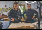 IN THE ARCHIVES – Aurélie Pollet and Gabrielle Dembinski read the August 3, 1929 edition of the Nome Nugget Newspaper inside the Nugget office on Friday, July 3. Photo by Ariana Crockett O’Harra