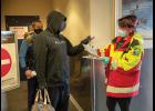 ARRIVAL IN NOME – Nome Emergency Services Technician Rose Reale checks an arrival’s travel permit in the Alaska Airlines terminal in Nome on Thursday